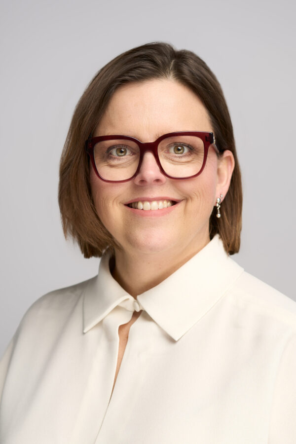 headshot of a woman wearing glasses and a white shirt